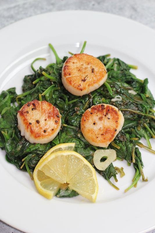 Seared scallops over spinach